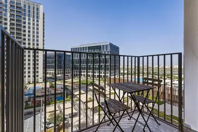 a balcony with a table and chairs and buildings at Silkhaus Chic 1BDR in Exclusive Neighbourhood in Dubai
