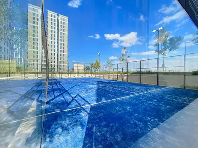 a tennis court with a net in a city at Silkhaus Chic 1BDR in Exclusive Neighbourhood in Dubai