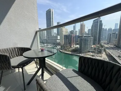 a balcony with a table and chairs and a view of the city at Luxury apartment 3 beds Marina view in Dubai
