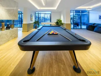 a pool table in the middle of a living room at Lovely 2BR at Belgravia Square, JVC by Deluxe Holiday Homes in Dubai