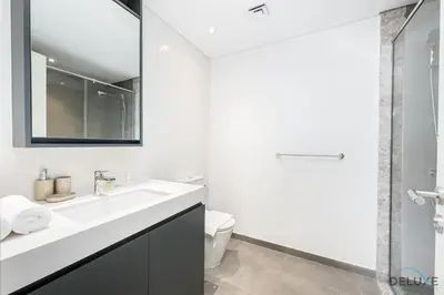 a white bathroom with a sink and a toilet at Lovely 2BR at Belgravia Square, JVC by Deluxe Holiday Homes in Dubai