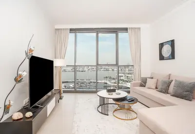 a living room with a couch and a large window at Superior New Luxury Living 2BR Apt Dubai Creek Harbour in Dubai