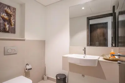 a white bathroom with a sink and a mirror at Superior New Luxury Living 2BR Apt Dubai Creek Harbour in Dubai