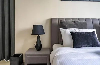 a bedroom with a bed and a lamp on a table at Homes Beyond l Spacious 2BR Creekside Lifestyle in Dubai