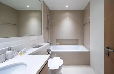 a bathroom with a tub and a sink and a toilet at Homes Beyond l Spacious 2BR Creekside Lifestyle in Dubai