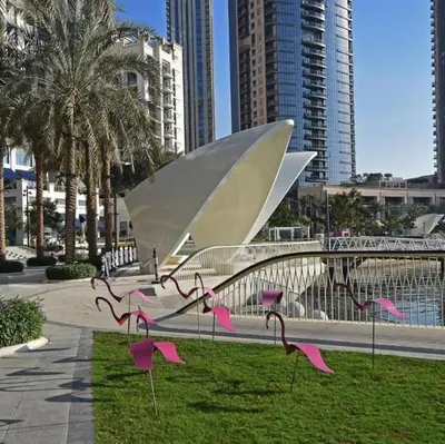 a bunch of pink flamingos in a park with buildings at Homes Beyond l Spacious 2BR Creekside Lifestyle in Dubai