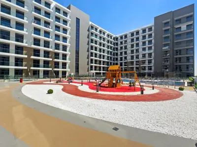 a playground in front of a large building at Modern Studio in residence with pool gym and paddl in Dubai
