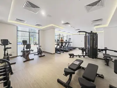 a gym with several treadmills and exercise bikes at Modern Studio in residence with pool gym and paddl in Dubai