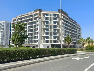 a large white building with a street in front of it at Modern Studio in residence with pool gym and paddl in Dubai