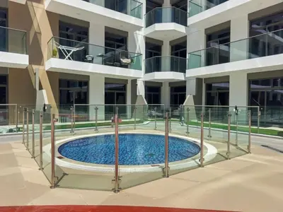 a swimming pool in front of a building at Modern Studio in residence with pool gym and paddl in Dubai