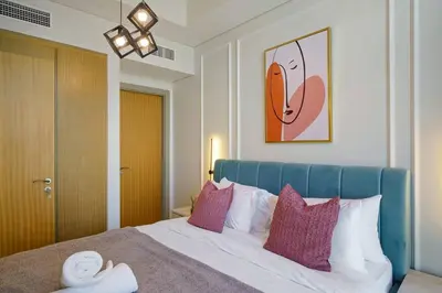 a bedroom with a bed with a blue headboard at High-Floor 2BR in Aykon City Spacious, Good View in Dubai