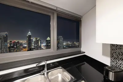 a kitchen with a view of a city skyline from a window at SmartStay at Paramount Tower - Sea and Downtown Views - Infinity Pool - Modern Luxury Residences in Dubai