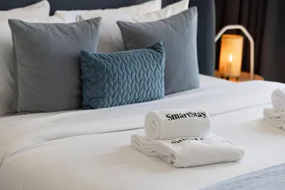 a bed with towels and pillows on it at SmartStay at Paramount Tower - Sea and Downtown Views - Infinity Pool - Modern Luxury Residences in Dubai