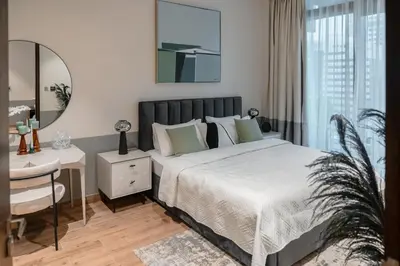 a bedroom with a bed and a desk and a mirror at Clever Guest 018 JL Marina gate in Dubai