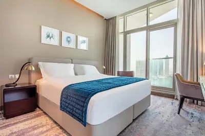a bedroom with a large bed and a large window at Prival - Prive in Dubai