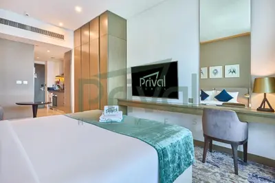 a bedroom with a bed and a desk with a chair at Prival - Prive in Dubai