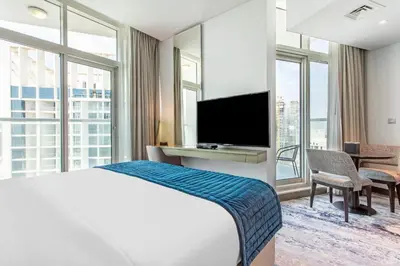 a hotel room with a bed and a flat screen tv at Prival - Prive in Dubai