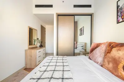 a bedroom with a bed and a mirror at GuestReady - Marvellous home at Binghatti Heights in Dubai