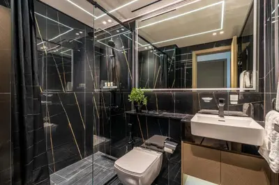 a bathroom with a toilet and a sink and a mirror at GuestReady - Marvellous home at Binghatti Heights in Dubai