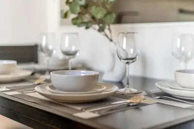 a table with plates and bowls and wine glasses at GuestReady - Marvellous home at Binghatti Heights in Dubai