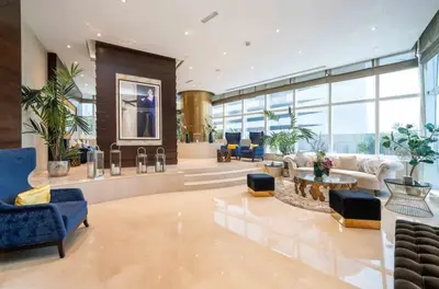 a lobby with blue chairs and tables and windows at Apartment Dubai Marina, Damac Heights 804 in Dubai