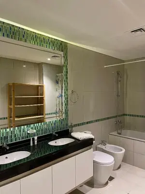 a bathroom with two sinks and a toilet and a mirror at Apartment Dubai Marina, Damac Heights 804 in Dubai