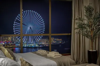 a room with a large window with a ferris wheel at Luxury Dubai Eye View Living - Beach access I Marina Walk in Dubai