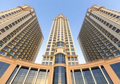 two tall buildings with a blue sky in the background at Cosmos Living Stunning Apt in Lago Vista IMPZ in Dubai