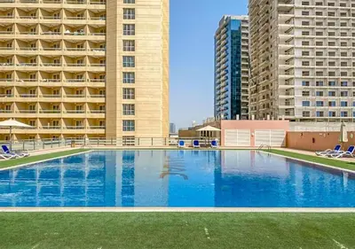 a large swimming pool in front of two tall buildings at Cosmos Living Stunning Apt in Lago Vista IMPZ in Dubai