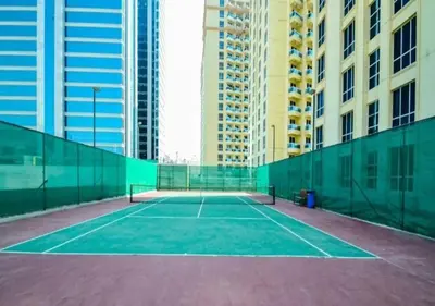 a tennis court in a city with tall buildings at Cosmos Living Stunning Apt in Lago Vista IMPZ in Dubai
