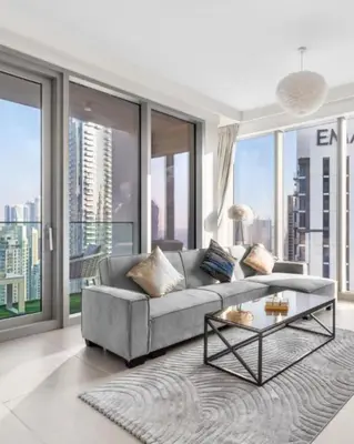 a living room with a couch and a glass table at Luxury 4-Bed Escape in Downtown Dubai That Sleeps 9 in Dubai