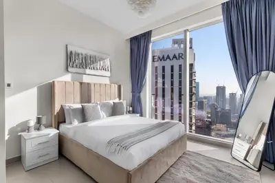 a bedroom with a large bed and a large window at Luxury 4-Bed Escape in Downtown Dubai That Sleeps 9 in Dubai