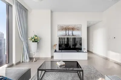 a living room with a tv and a table at Luxury 4-Bed Escape in Downtown Dubai That Sleeps 9 in Dubai