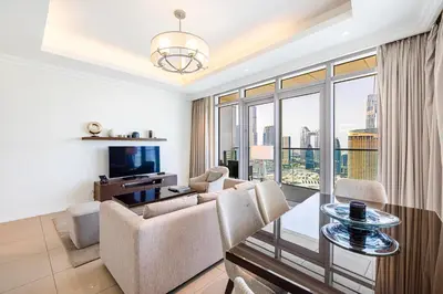 a living room with a couch and a table and chairs at The Address Fountain Views - Residence 2 Bedroom with Burj Khalifa view and access to Dubai mall in Dubai