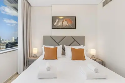 a bedroom with a large white bed and a window at DIFC 1BR at SkyGardens Tower in Dubai
