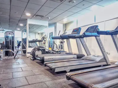 a gym with several treadmills and elliptical machines at DIFC 1BR at SkyGardens Tower in Dubai