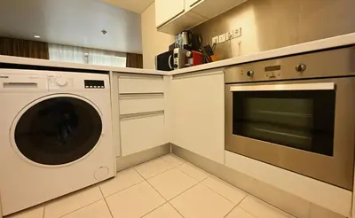 a kitchen with a washer and dryer at Four Apple EMAAR Fashion Avenue Deluxe Studio in Dubai