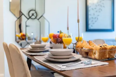 a table with plates and bowls of bread and glasses of orange juice at FIRST CLASS 2BR In the HEART of Downtown Dubai in Dubai