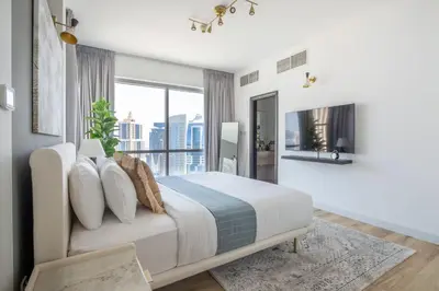 a bedroom with a bed and a large window at Frank Porter - La Riviera Tower in Dubai