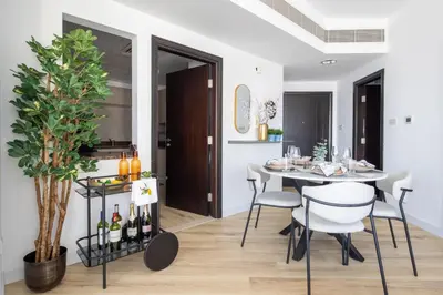 a dining room with a table and chairs and a plant at Frank Porter - La Riviera Tower in Dubai