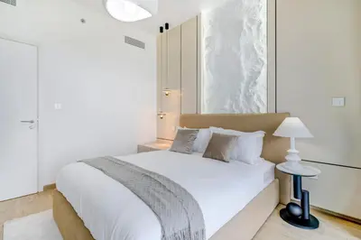 a bedroom with a large white bed with a lamp at Trophy Live in the Sky Luxury Moon Collection Suites with DIFC Views 45Th Floor in Dubai