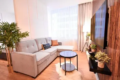 a living room with a couch and a tv at Heart of DIFC: SKY Gardens Modern Chic Studio in Dubai