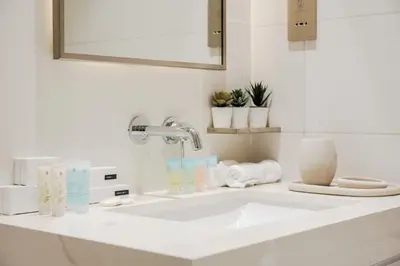 a bathroom with a white sink and a mirror at Stayis I Beachfront Luxury 1BR with Private Access in Dubai