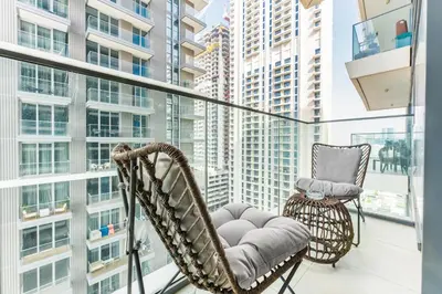 two chairs on a balcony with a view of a city at Stayis I Beachfront Luxury 1BR with Private Access in Dubai