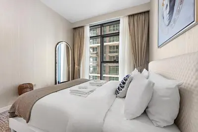 a bedroom with a large white bed with a window at Stayis I Beachfront Luxury 1BR with Private Access in Dubai