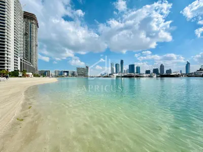 a view of a beach with a city in the background at Sea and Palm View from 1BD apt in Beachfront in Dubai