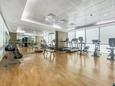 a gym with treadmills and exercise equipment in a room at Silkhaus Modern Studio in The Heart of DIFC in Dubai