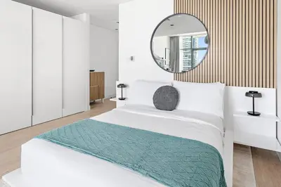 a bedroom with a white bed with a mirror at Silkhaus Modern Studio in The Heart of DIFC in Dubai