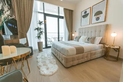 a bedroom with a large bed and a table and chairs at Wonderful Studio with Balcony & City Views in Dubai