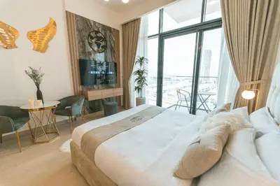 a hotel room with a large bed and a tv at Wonderful Studio with Balcony & City Views in Dubai